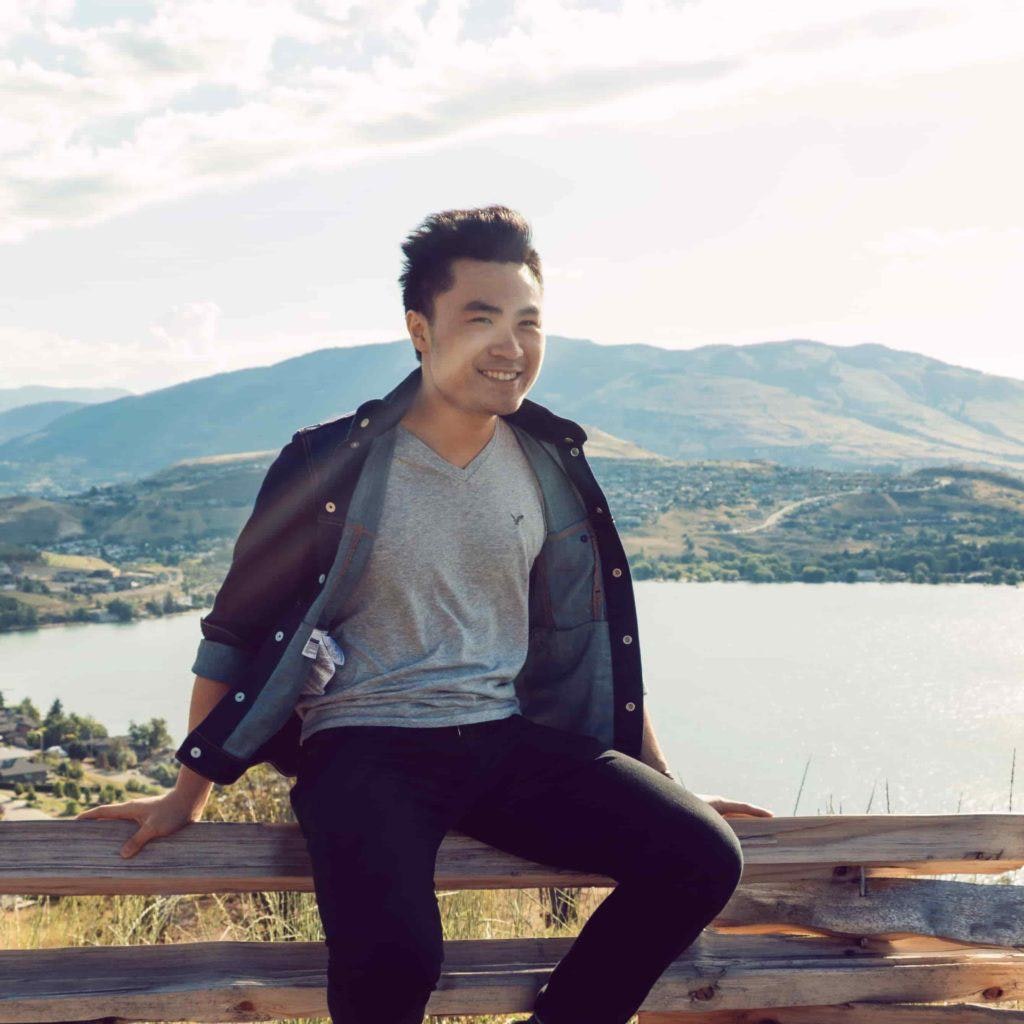 Chester Lee on a fence in front of a lake